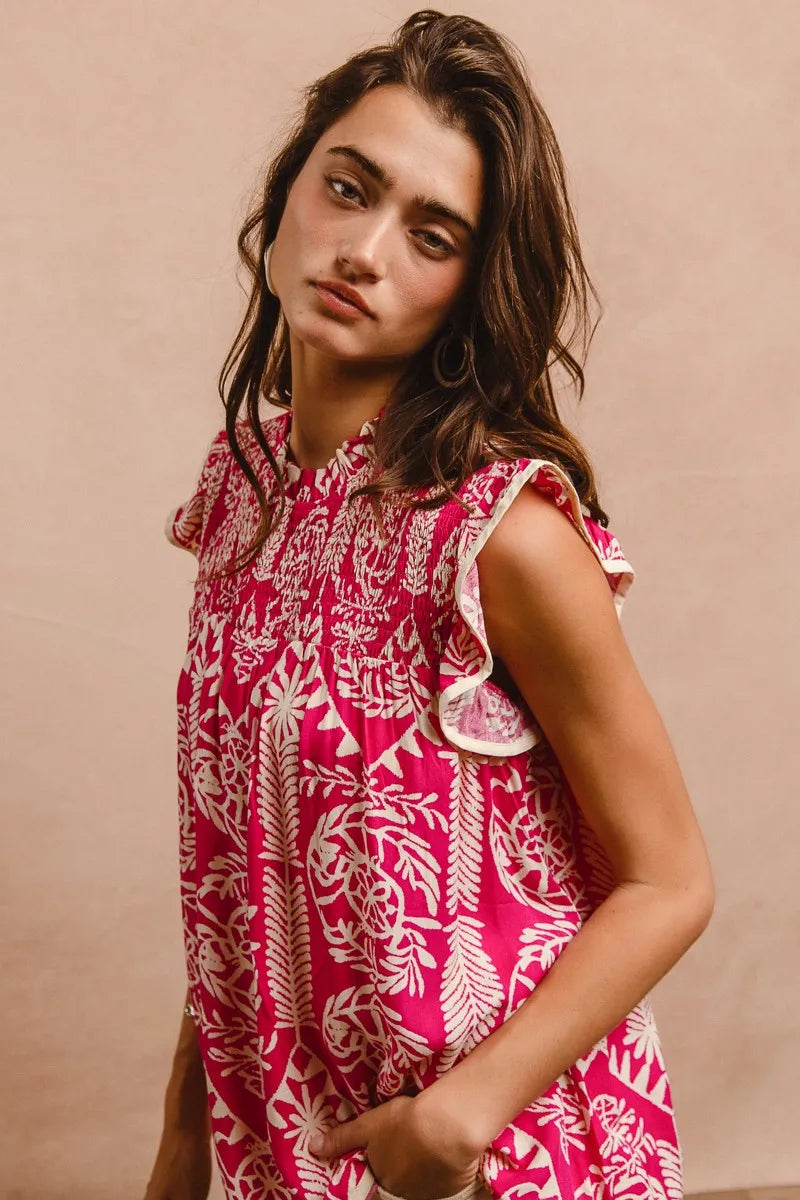 Woman wearing a pink and white patterned dress against a beige background