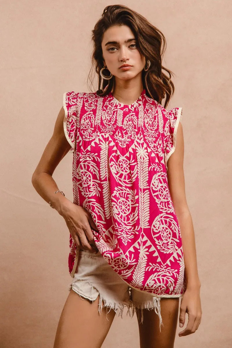 Woman wearing a pink and white patterned sleeveless top against a beige background