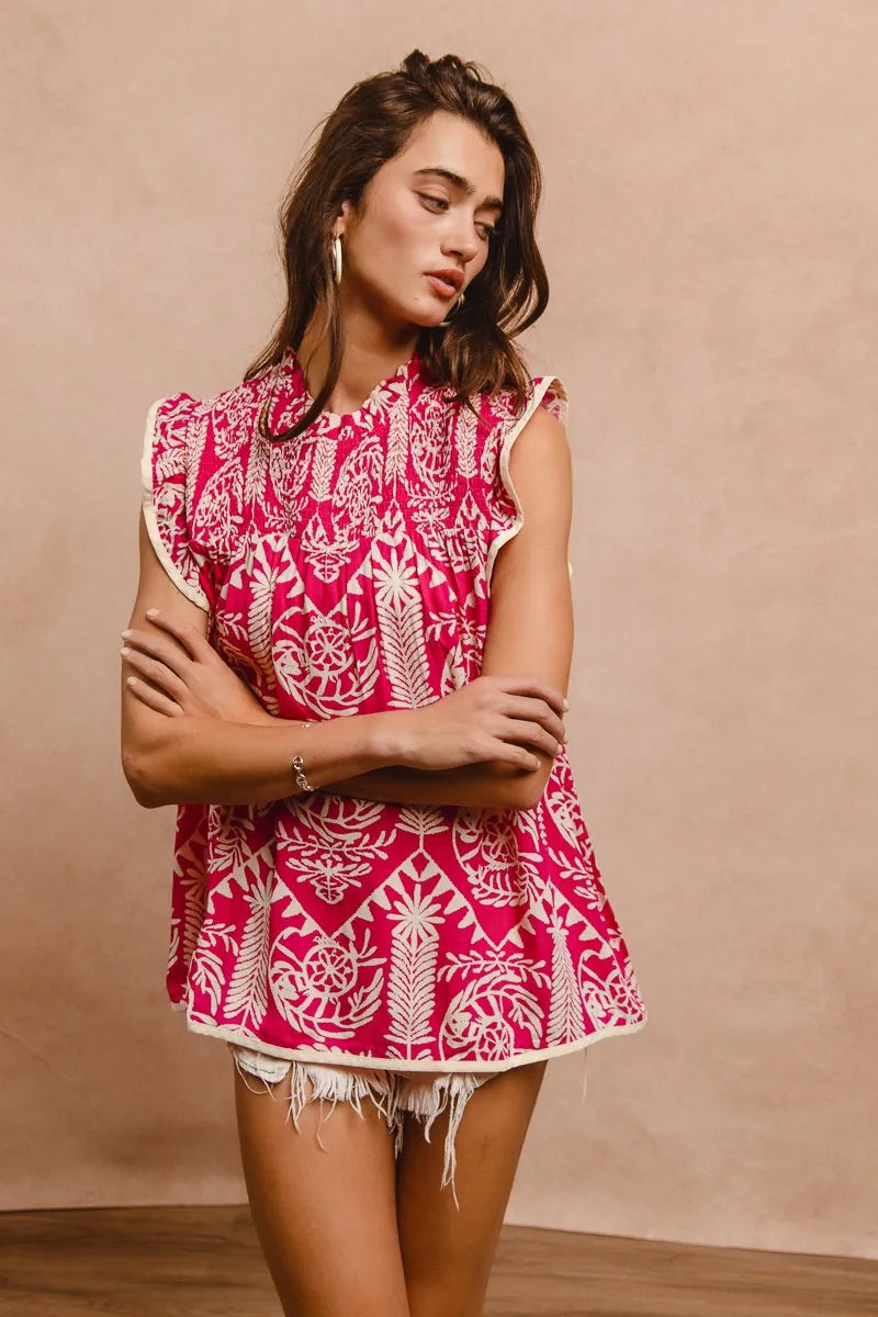 woman wearing pink and cream pattern top with ruffle sleeves