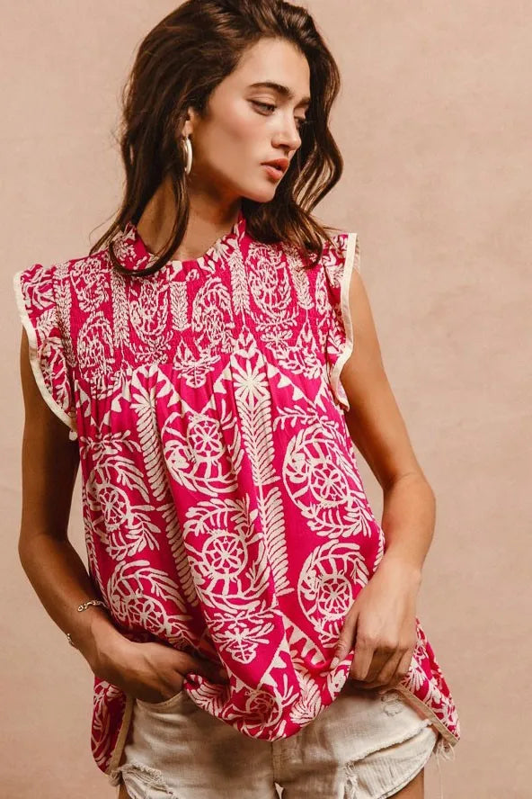 woman wearing pink and cream pattern top with ruffle sleeves