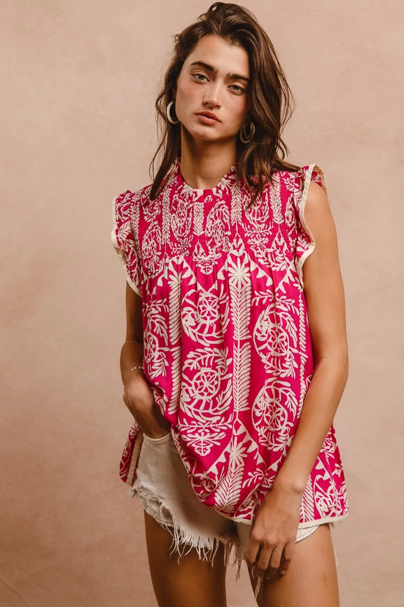 Woman wearing a pink and white patterned sleeveless top against a beige background
