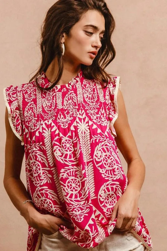 Woman wearing a pink and white patterned top against a beige background