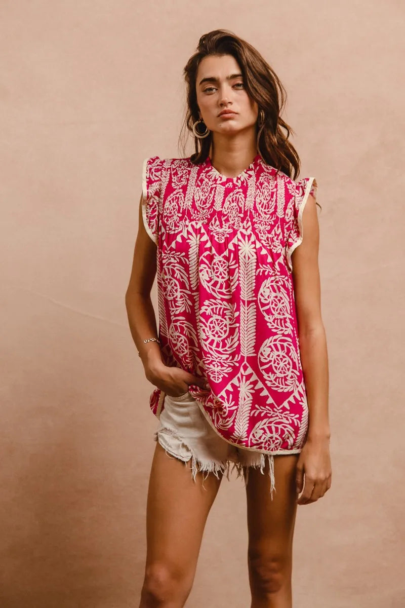 Woman wearing a pink and white patterned sleeveless top against a beige background