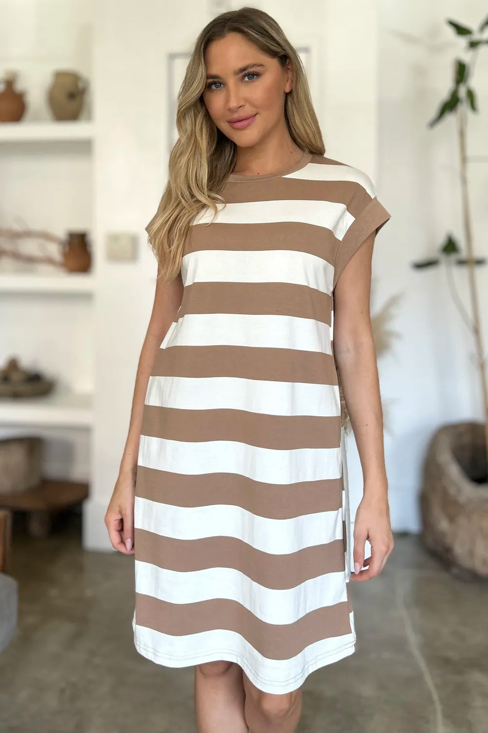 Woman wearing a brown and white striped dress in a home setting