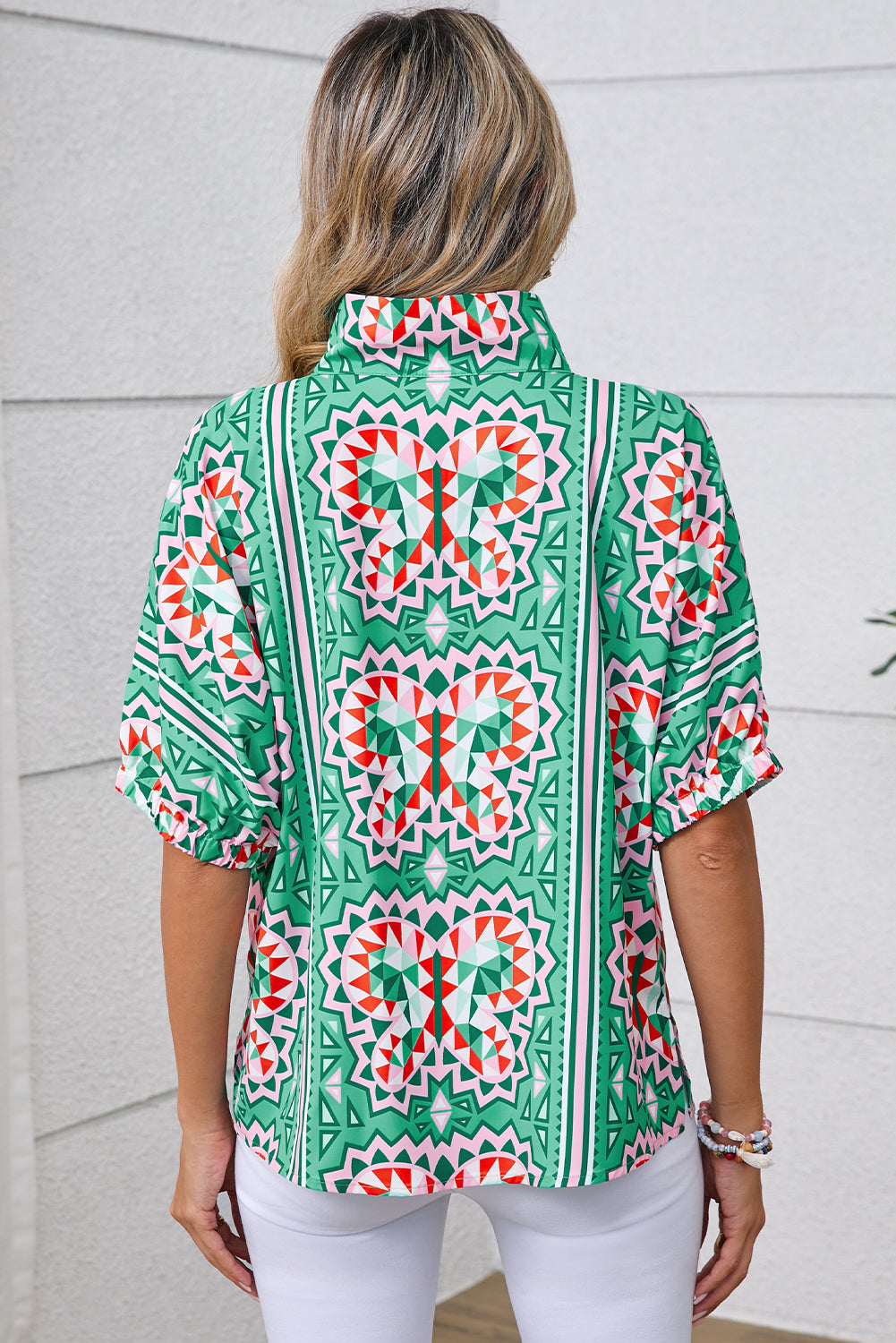 Person wearing a green patterned shirt with a white background