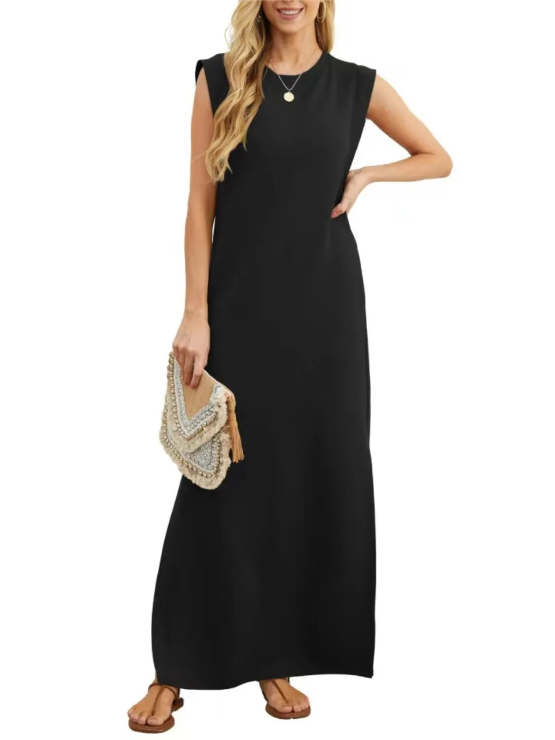 Woman wearing a black sleeveless dress holding a beige clutch on a white background
