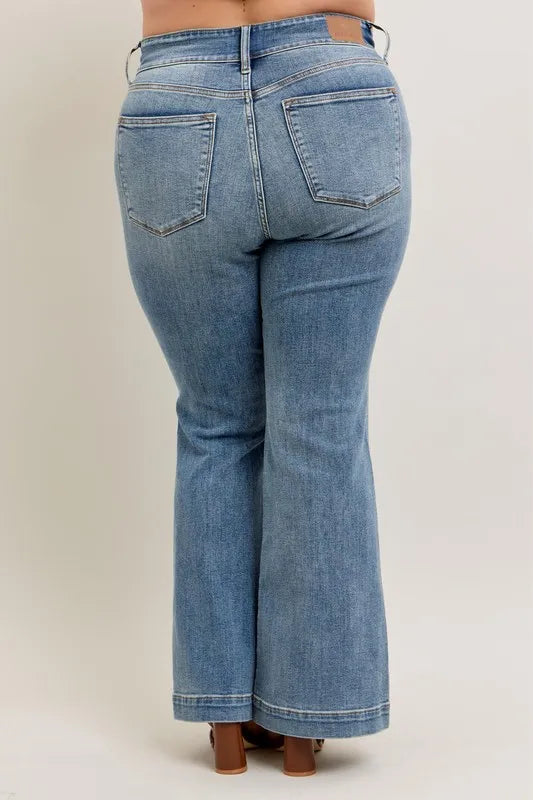 Blue jeans worn by a person on a plain background