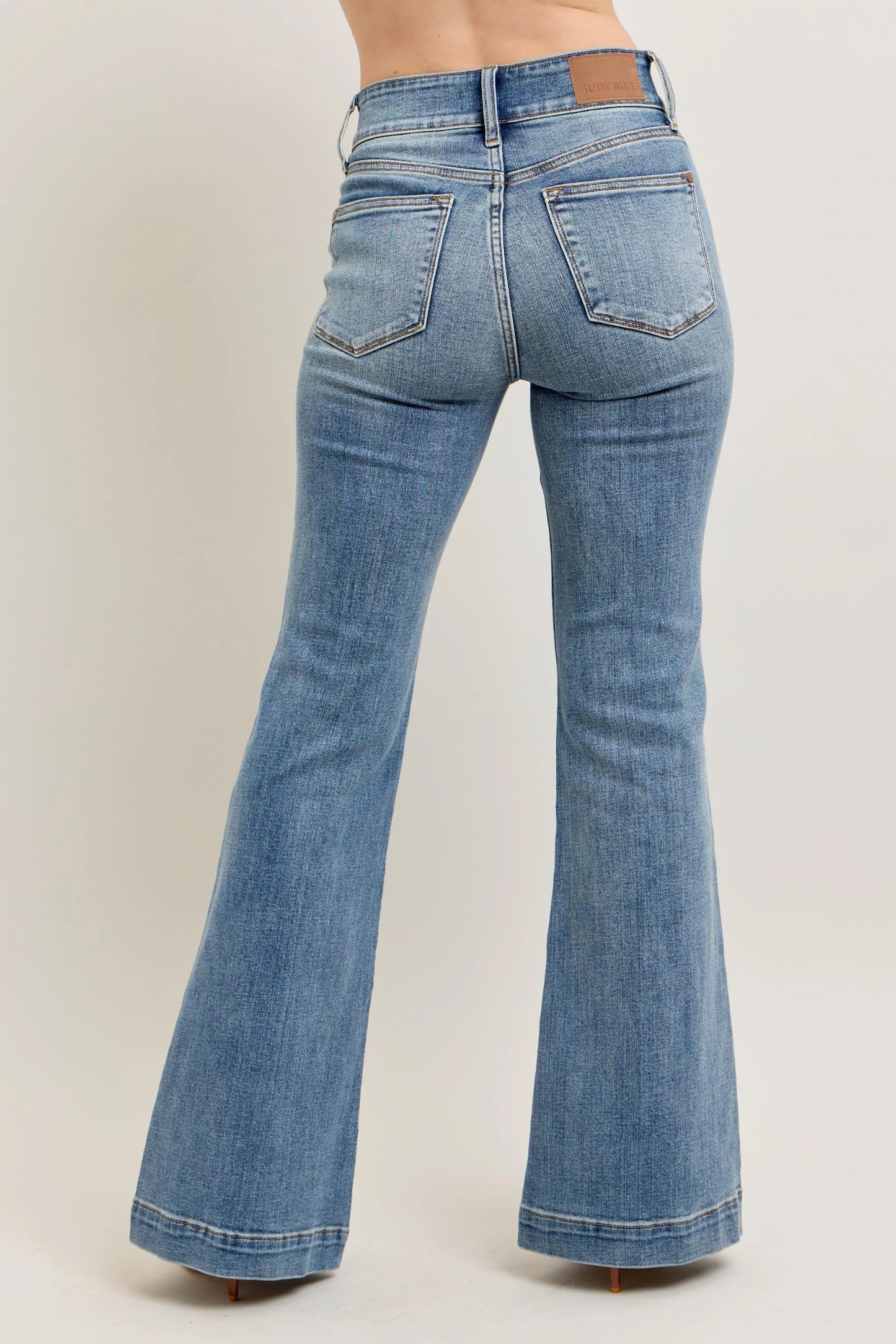 Blue flared jeans on a beige background