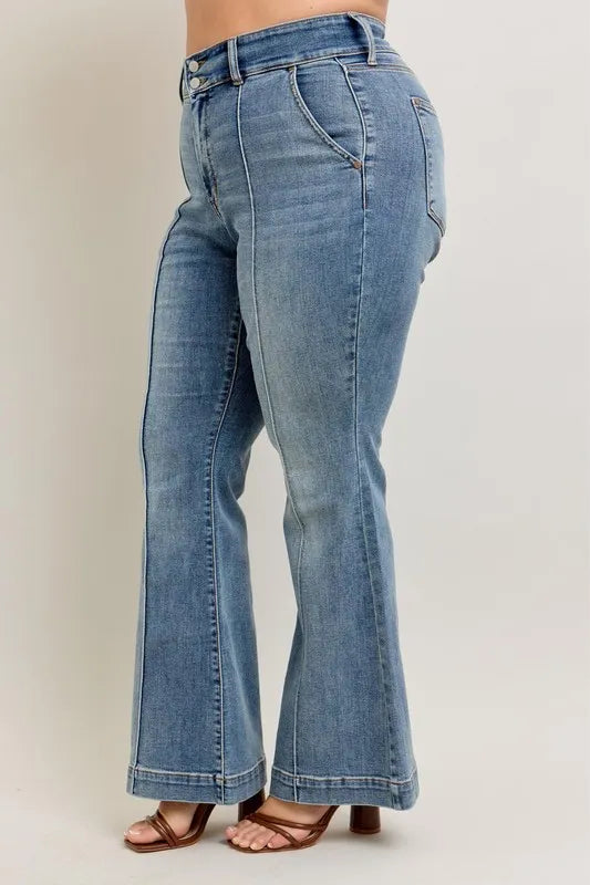 Blue jeans worn by a person on a plain background