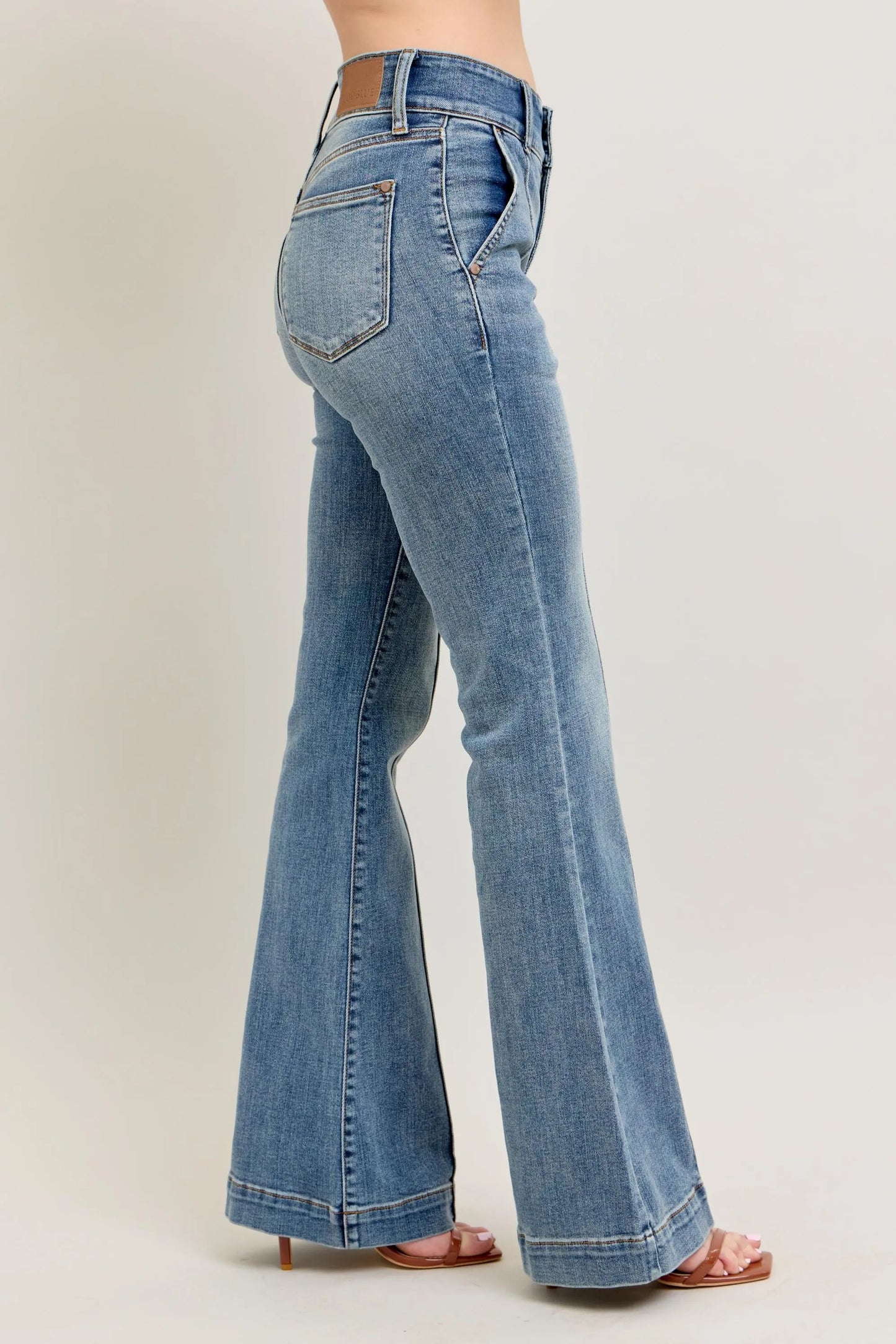 Blue jeans worn by a person on a plain background