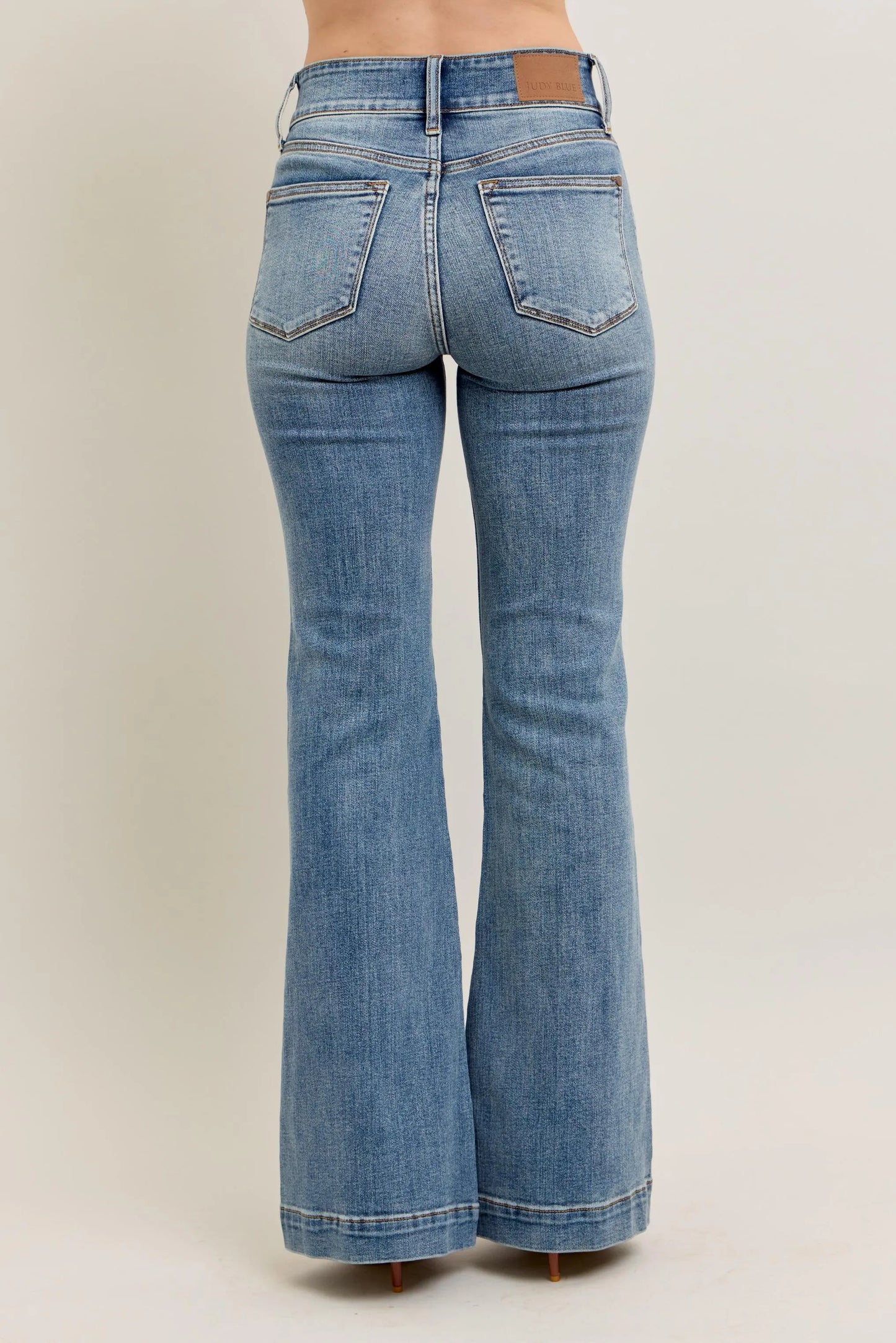 Blue flared jeans on a plain background