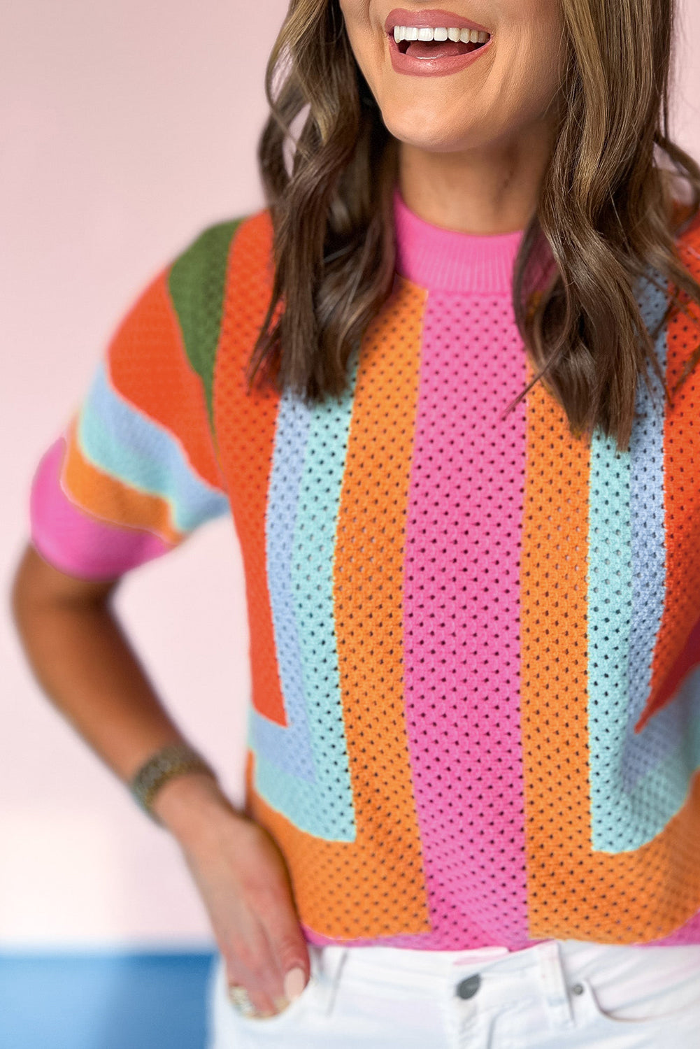 Person wearing a colorful striped sweater with a blurred background