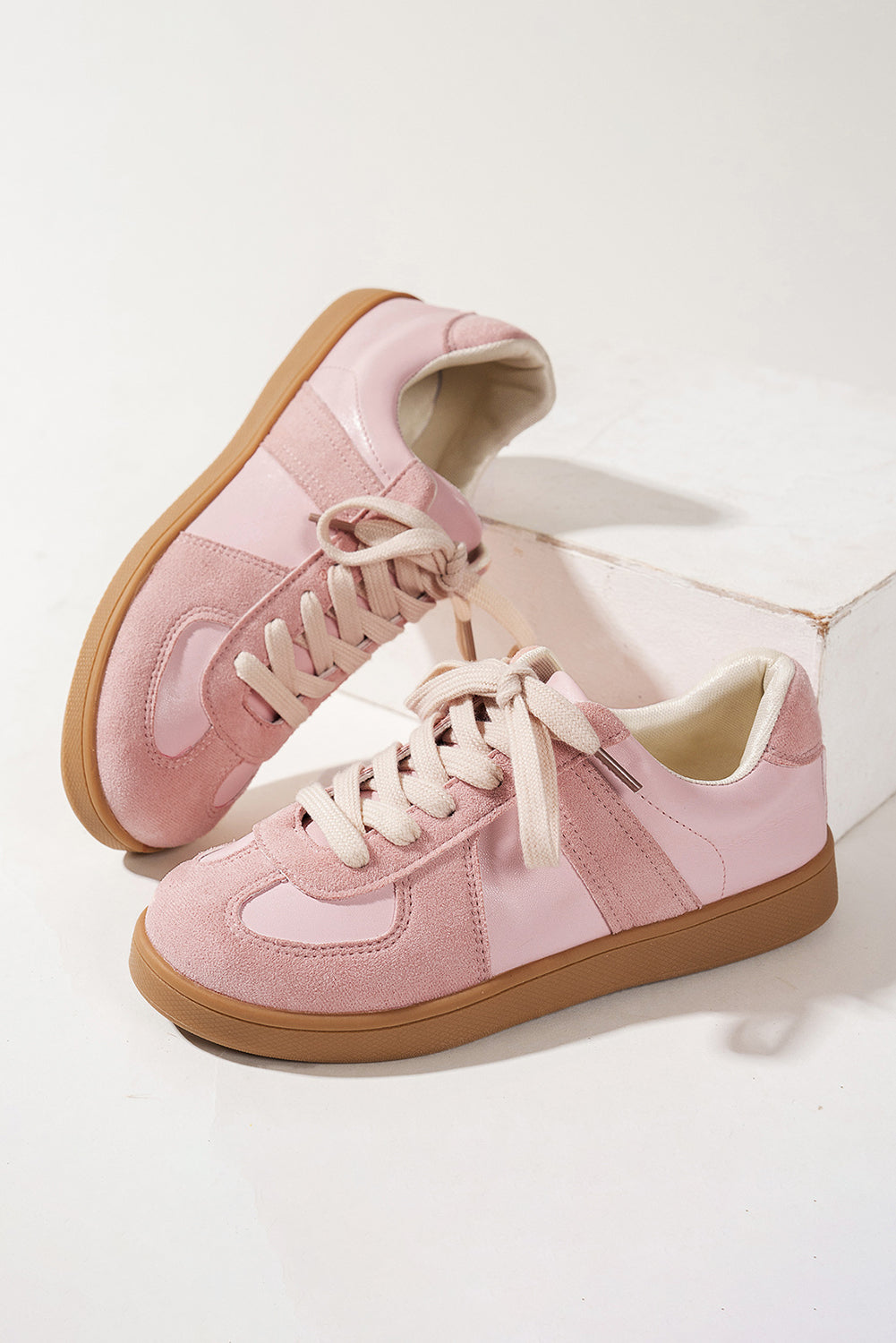 Pink sneakers with brown soles on a white background