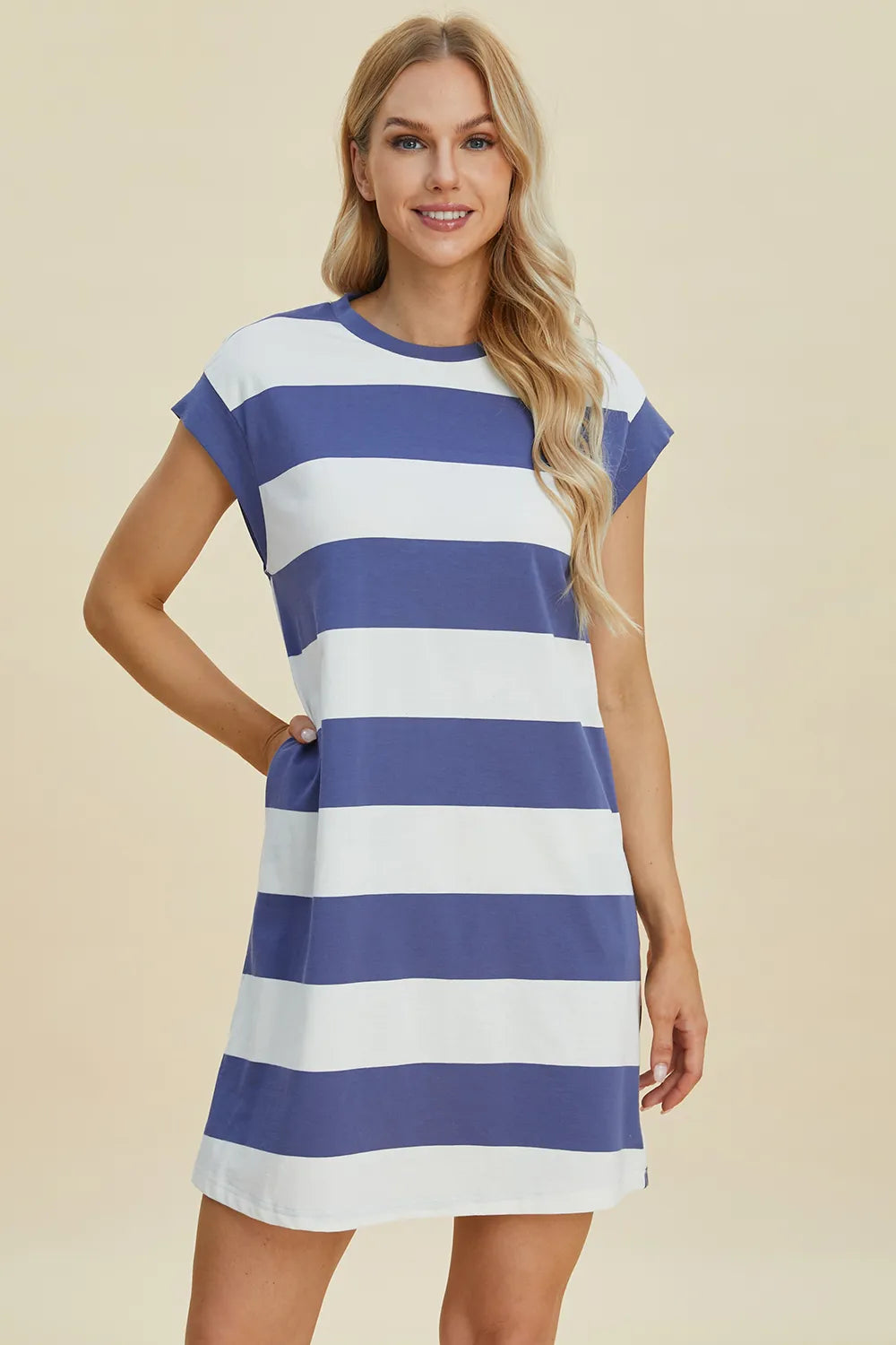 Woman wearing a blue and white striped dress on a beige background