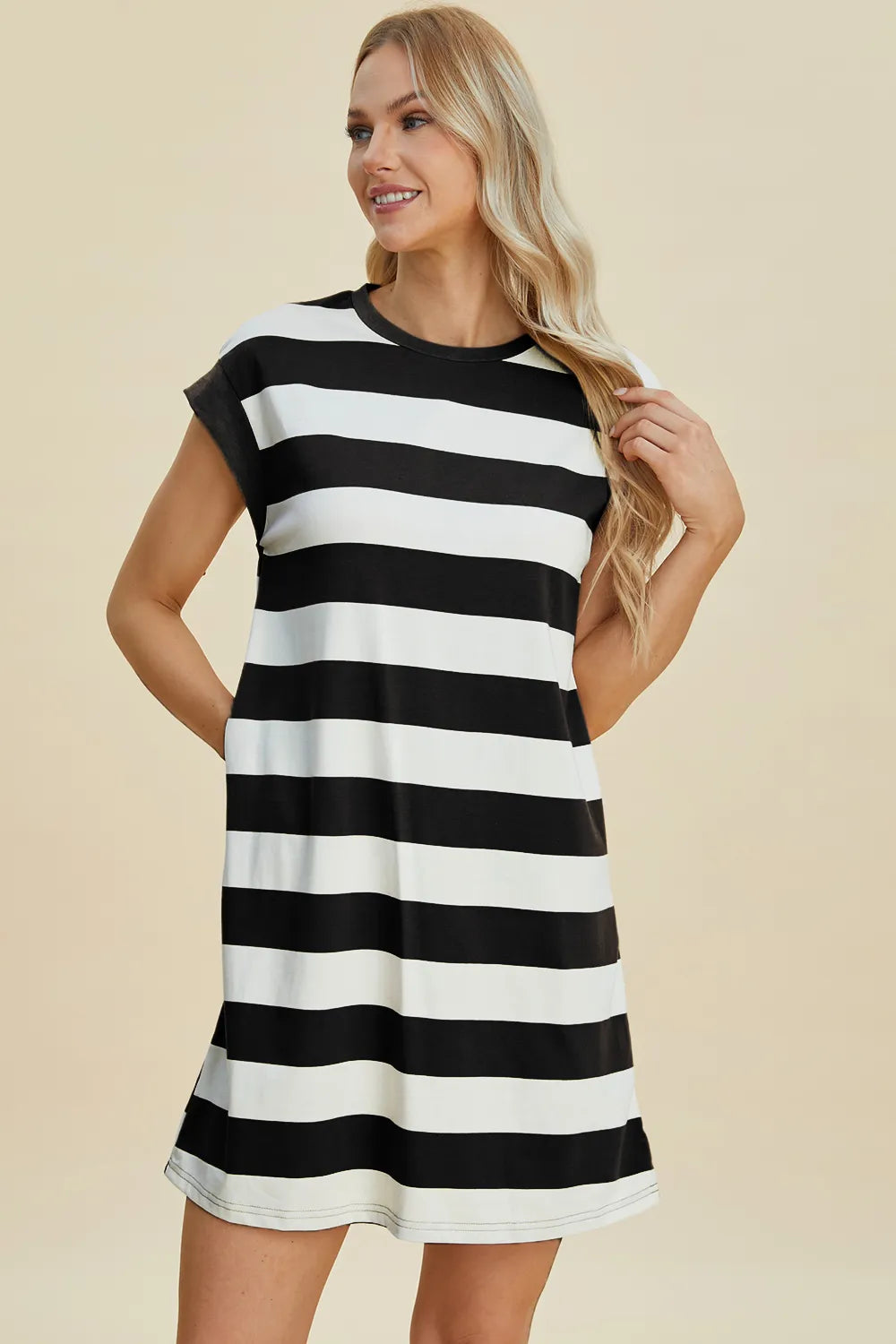 Woman wearing a black and white striped dress on a beige background