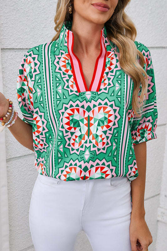 Woman wearing a colorful patterned blouse with a white background