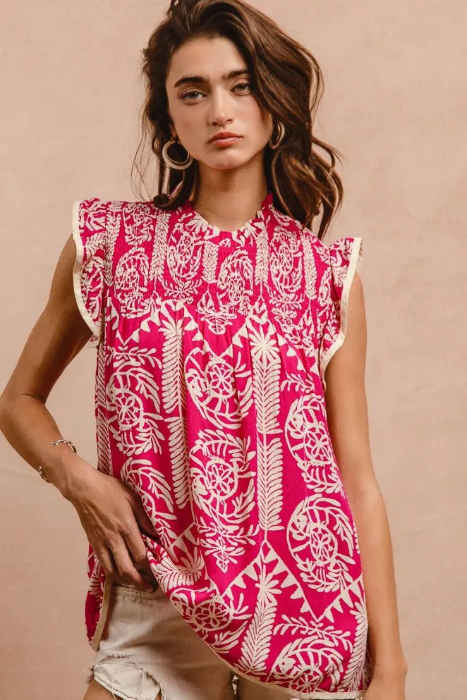 Woman wearing a pink and white patterned sleeveless top against a beige background
