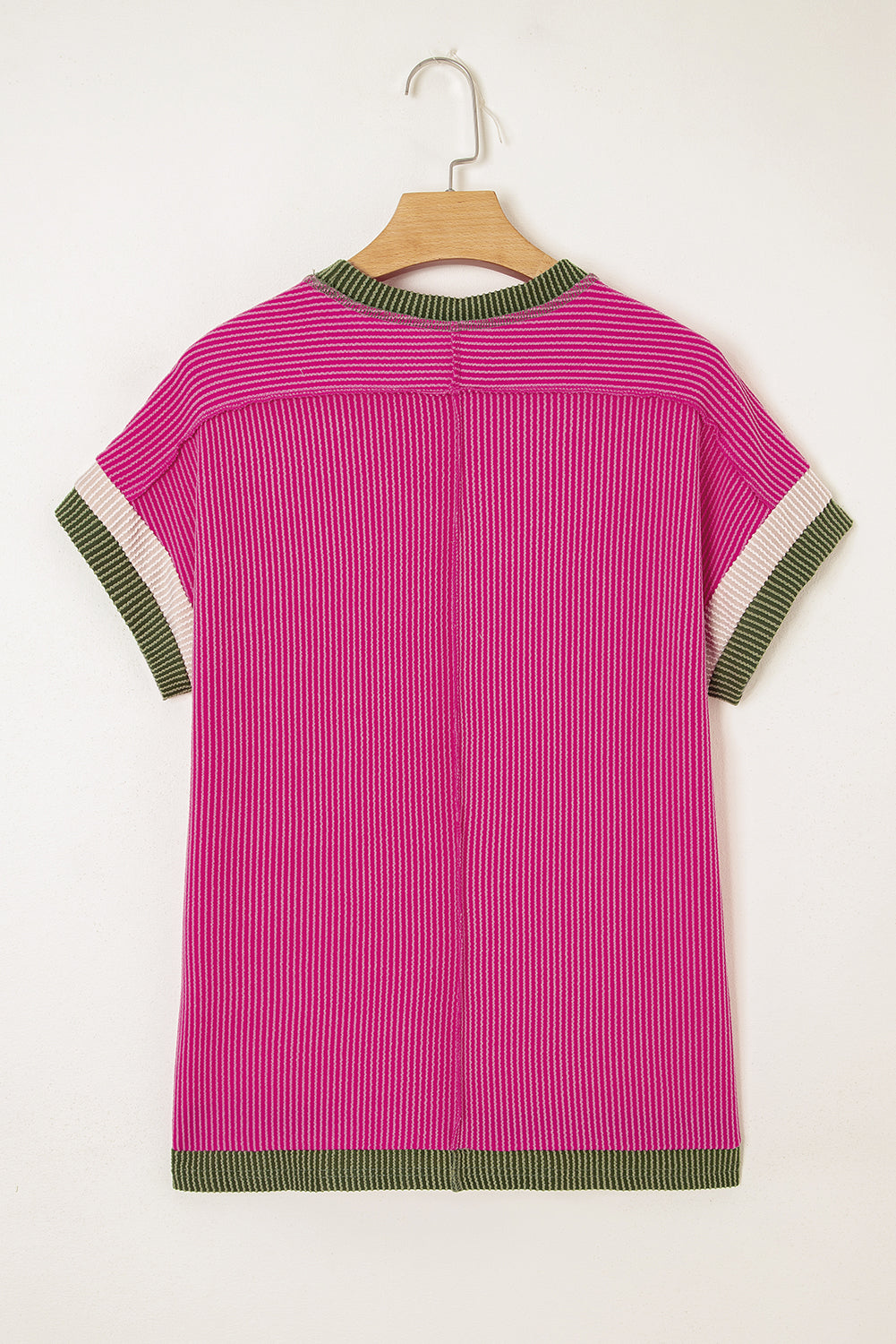 Pink top with green and white trim on a hanger against a white background