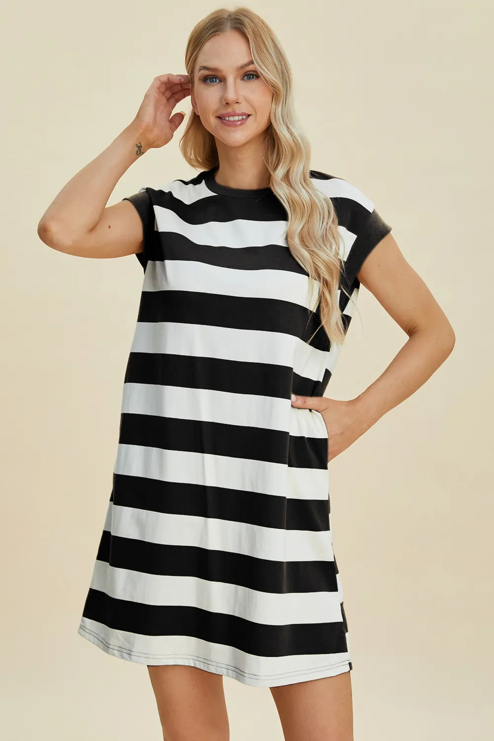 Woman wearing a black and white striped dress on a beige background