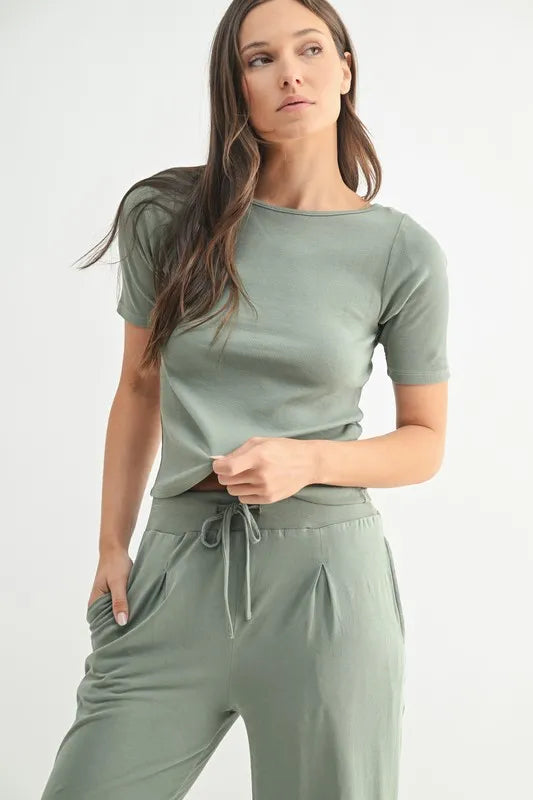 Woman wearing a green loungewear outfit on a white background
