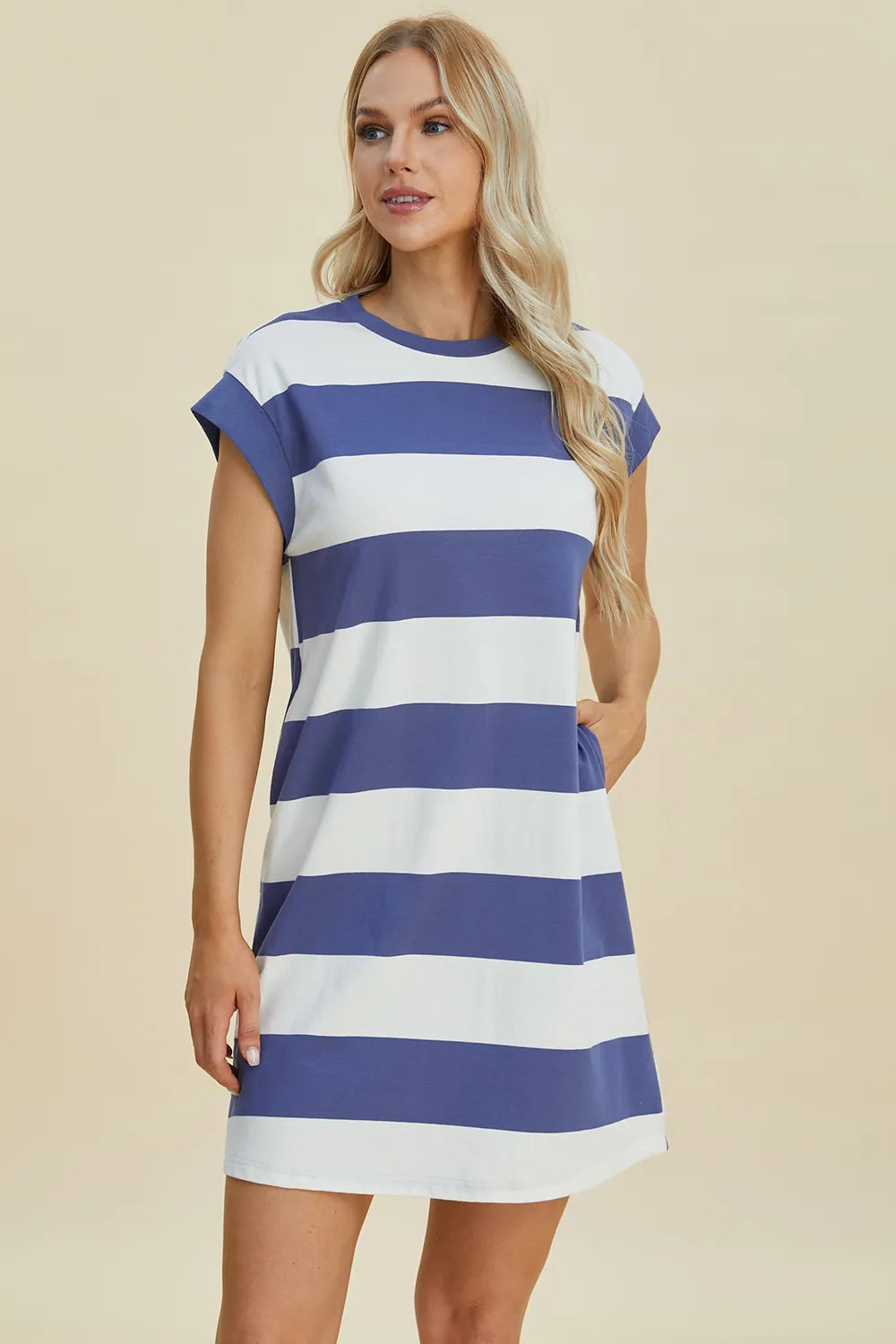 Woman wearing a blue and white striped dress on a beige background
