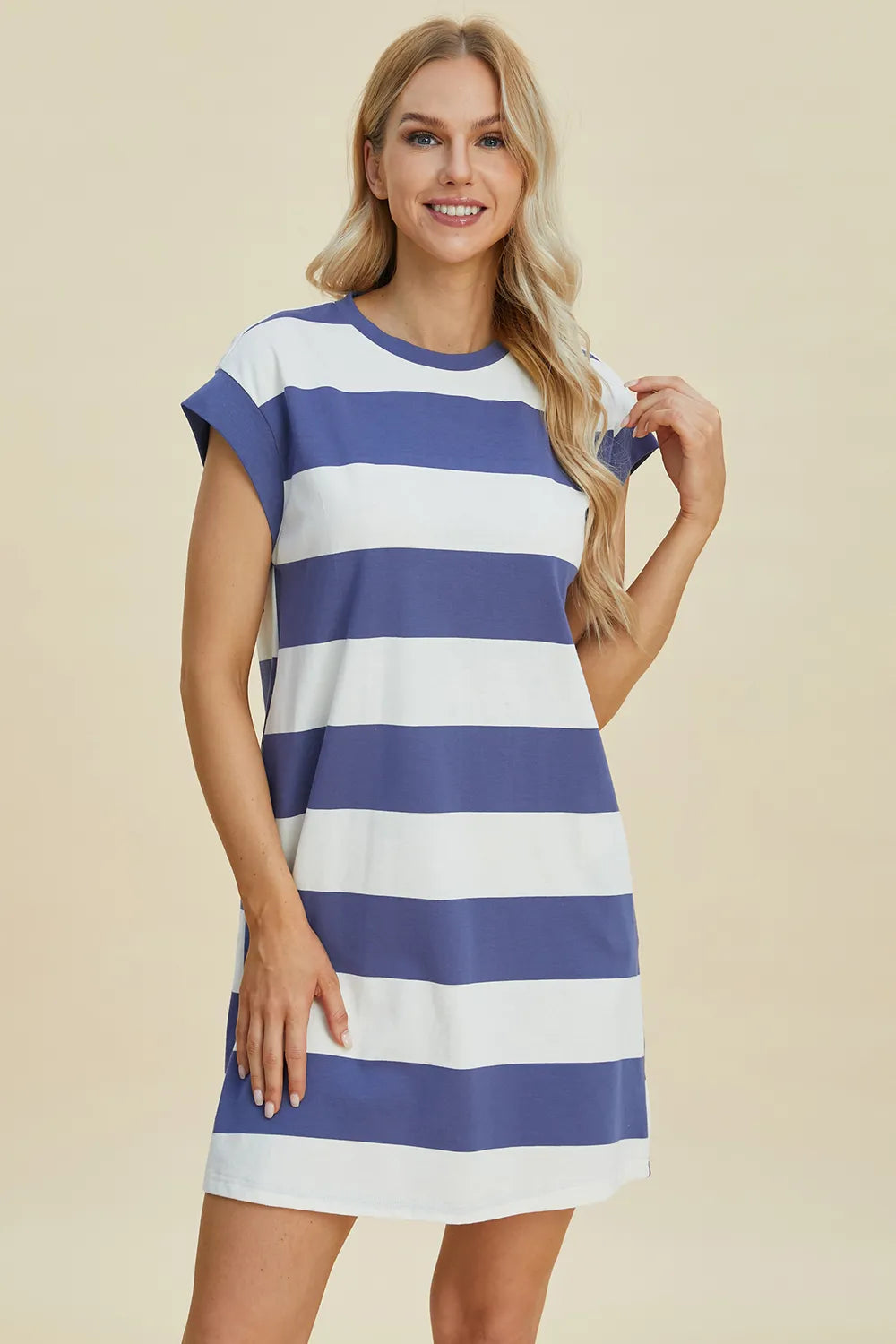Woman wearing a blue and white striped dress on a beige background